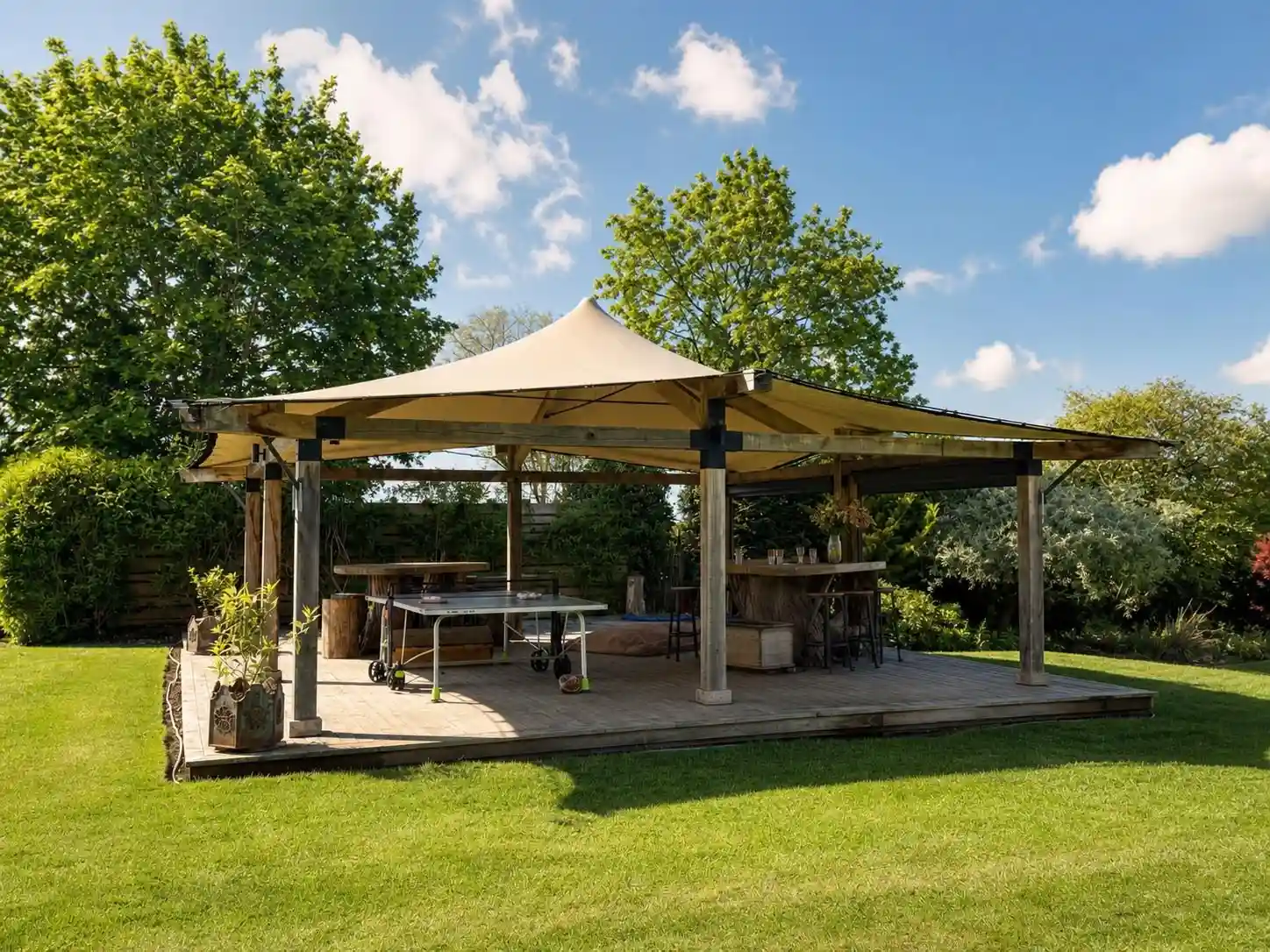 An outdoor gathering and dining space surrounded by mature trees